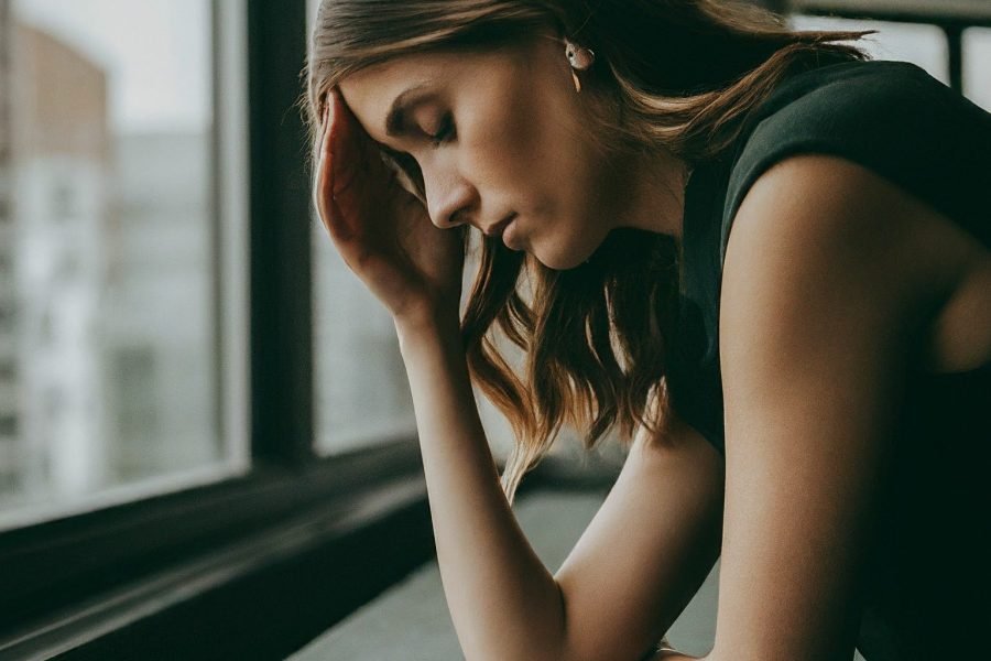 personne réfléchissant devant une fenêtre